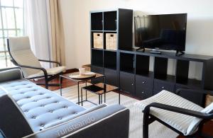 a living room with a couch and a tv at Chalet Adosado Proa - Parking y jardín con impresionantes vistas a la Ría de San Vicente de la Barquera in San Vicente de la Barquera