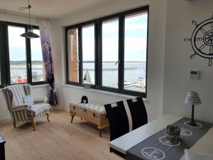 a living room with a table and chairs and windows at Sunshine Speicherresidenz Barth in Barth