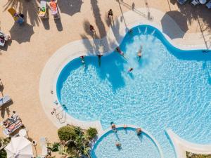 an overhead view of a swimming pool with people in it at Hotel Ipomea Club in Capo Vaticano