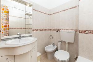 a bathroom with a sink toilet and a mirror at Casa da Praia in Armação de Pêra +13 photos