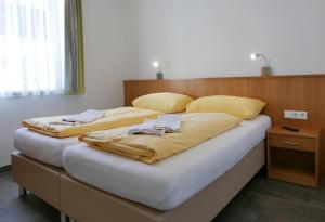 a large bed with two pillows on top of it at Deluxe Apartment SCHRABERGER in Schladming