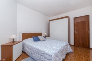 sypialnia z łóżkiem z niebieskimi poduszkami w obiekcie Casa da Praia w Armação de Pêra