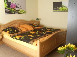 sypialnia z drewnianym łóżkiem z kwiatami w obiekcie Ferienhaus am Schloßpark w mieście Putbus