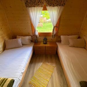two beds in a room with a window at Vila Helena in Colići
