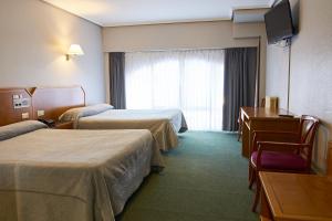 a hotel room with two beds and a television at Hotel San Jorge in Santurce