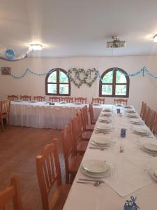 un comedor con mesas y sillas con manteles blancos en Villa Rigo Panzió, en Verpelét