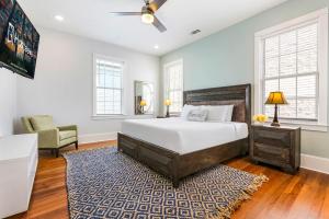 ニューオーリンズにあるHosteeva Brand New Condo with a Pool Steps to St Charles Aveのベッドルーム1室(ベッド1台、椅子、窓付)