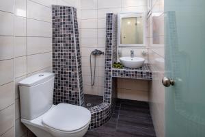
a bathroom with a toilet, sink, and bathtub at Alizea Villas & Suites in Fira

