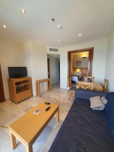 salon z niebieską kanapą i stołem w obiekcie Atardecer Beach Costa w mieście Benalmádena