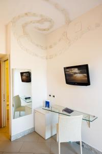 an office with a glass desk and a tv on the wall at Art Hotel Gran Paradiso in Sorrento