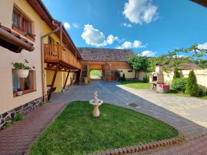 a courtyard of a house with a fountain in the grass at Casa Simion in Sibiu