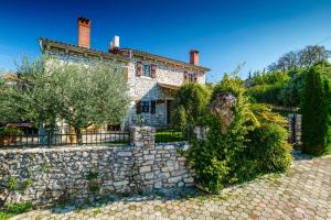 an old stone house with a stone fence at Haus Albino in Kršan
