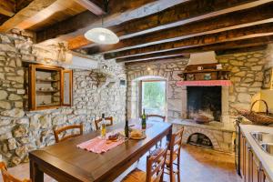 a kitchen with a wooden table and a stone wall at Haus Albino in Kršan