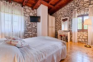 a bedroom with a bed and a stone wall at Haus Albino in Kršan +55 photos