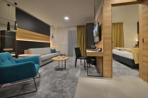 兹诺伊莫PREMIUM Wellness & Wine Hotel Znojmo的配有沙发和床的酒店房间