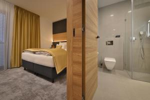 兹诺伊莫PREMIUM Wellness & Wine Hotel Znojmo的带床和淋浴的酒店房间