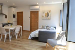 a bedroom with a bed and a table and a kitchen at Housingleón - Apartamentos Fauno in Astorga