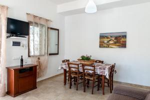 a dining room with a table and chairs and a television at Villa Oleandro in Alcamo Marina