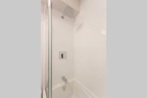 bagno bianco con doccia e vasca. di Live Like a Local in this Superb Loft by Den Stays a Montréal