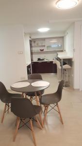 a room with two tables and chairs and a kitchen at Orhidea Szuterén Apartman in Győr