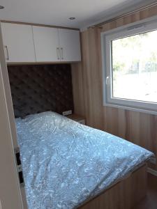 una camera da letto con un letto con una coperta blu sopra di GARDENIA RAJGRÓD a Rajgród