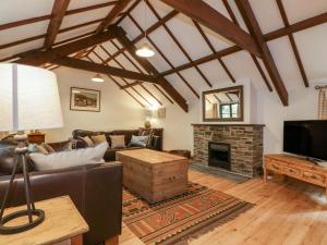 a living room with a couch and a fireplace at Ribby Barn in Lostwithiel