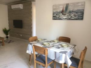 a dining room table with a white table cloth on it at Seaside Apartment in Taʼ Xbiex