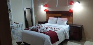 ein Schlafzimmer mit einem Bett mit roten Luftballons darauf in der Unterkunft Hotel Alpamayo Cajamarca in Cajamarca