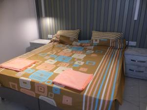 a bed with a colorful blanket on top of it at Seaside Apartment in Taʼ Xbiex