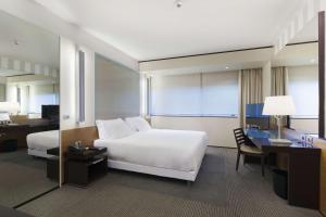 a hotel room with a white bed and a desk and a desk at NH Venezia Laguna Palace in Mestre