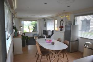 eine Küche und ein Esszimmer mit einem Tisch und einem Kühlschrank in der Unterkunft Ferienhaus Grafenland in Dersum