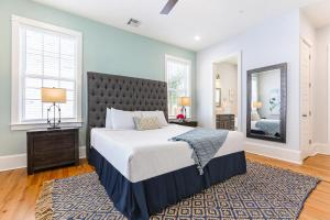 a bedroom with a large bed and a mirror at Stunning 4BR-5BR near French Quarter Homes by Hosteeva in New Orleans