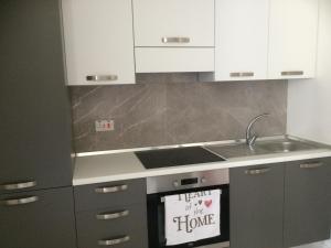 a kitchen with white cabinets and a stove top oven at Seaside Apartment in Taʼ Xbiex