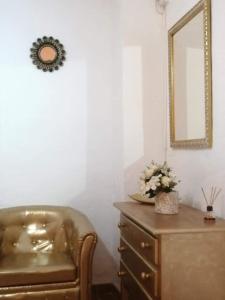 Habitación con tocador, espejo y silla. en H Juan, en Marbella