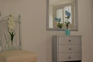 a bedroom with a dresser and a mirror and a chair at H Juan in Marbella