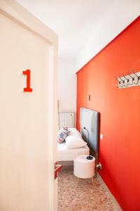 1 dormitorio con cama y pared roja en Casa del Corso, en Sorrento