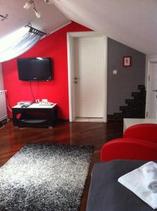 a living room with a red wall with a tv at Sunny House in Skopje
