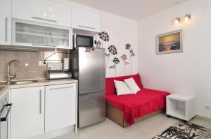 una cucina con divano rosso e frigorifero di Full equipped flat close to all a Spalato (Split)