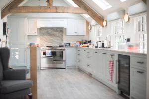 a kitchen with white cabinets and a stove top oven at Iris 5 Star Gold Award Luxury Cottage in St Ives