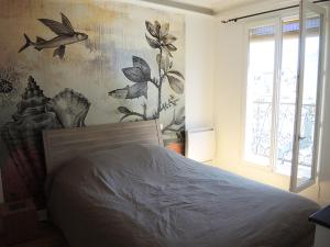 Schlafzimmer mit einem Bett und einem Fenster in der Unterkunft 2 Pièces avec Balcon Plein Sud in Paris