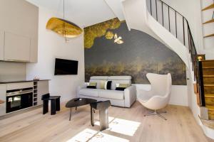 a living room with a couch and a staircase at La Noctambulle Forum in Reims