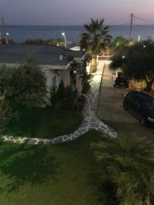 a garden with a rock pathway in front of a house at Vrachos Holidays Hotel in Paralia Vrachou