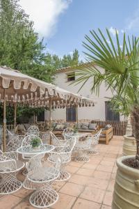 a group of white chairs and tables on a patio at Hotel El Molino in Monreal del Campo