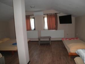 a room with two beds and a flat screen tv at Casa Didina in Năvodari