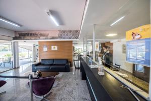 ein Wohnzimmer mit einer Bar und einer Couch in der Unterkunft San Diego Suites Pampulha Hotel - Oficial in Belo Horizonte