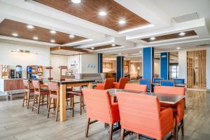 a dining area with tables and chairs in a cafeteria at Holiday Inn Express Hotel & Suites Tappahannock by IHG in Tappahannock