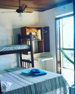 a bedroom with a bunk bed with a blue shirt on a table at Pousada Marambaia in Caraguatatuba