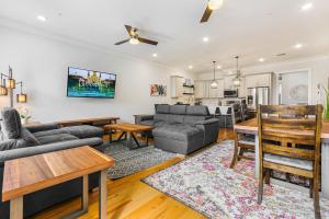 ニューオーリンズにあるModern 5 BR Condo - Large Pool - Near Everythingのソファとテーブルのあるリビングルーム