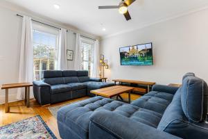 ニューオーリンズにあるModern 5 BR Condo - Large Pool - Near Everythingのリビングルーム(青いソファ、テレビ付)