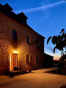 a large brick building with a light on the door at Domaine de Cazal - Chambres d'Hôtes avec piscine au cœur de 26 hectares de nature préservée in Saint-Cyprien